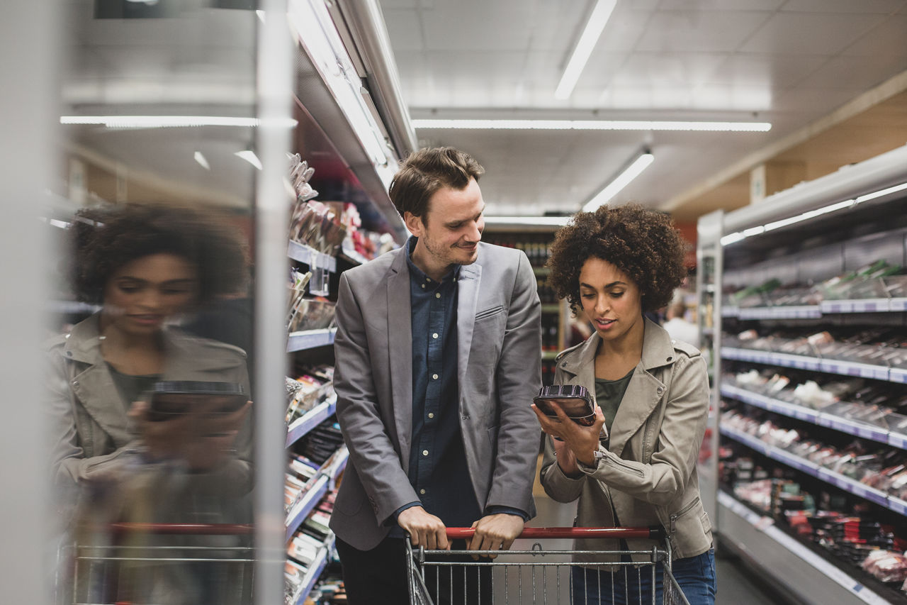 Couple choosing a ready meal in grocery store